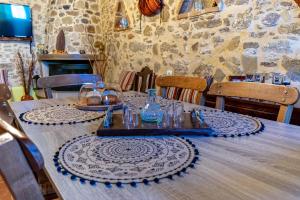 una mesa de madera con platos y vasos. en Traditional Mansion, en Kaláthenai