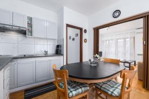 cocina y comedor con mesa y sillas en Vlado, en Poreč