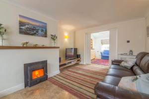 a living room with a couch and a fireplace at Bosky House in South Creake