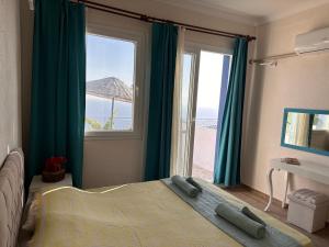 a bedroom with a bed and a large window at Goknar Knidos Oasis Nature Hotel in Datca