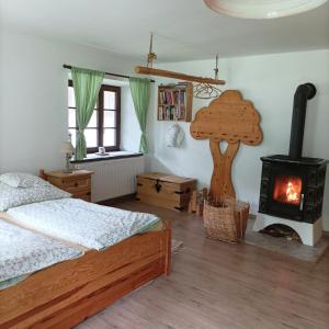 ein Schlafzimmer mit einem Bett und einem Holzofen in der Unterkunft Old house in Forest in Křemže