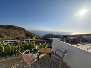 Un balcón con sillas, una mesa y el océano en Goknar Knidos Oasis Nature Hotel, en Datça
