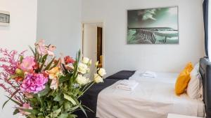 - une chambre avec un lit et des fleurs à l'étage dans l'établissement Albert gare du Midi , 29, à Bruxelles