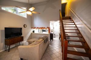 a living room with a staircase and a couch and a television at Southern Sanctuary in Tallahassee