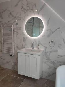 a bathroom with a white sink and a mirror at La Suite in Vron