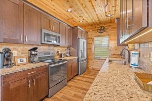 a kitchen with wooden cabinets and stainless steel appliances at Dolly Valley View in Sevierville