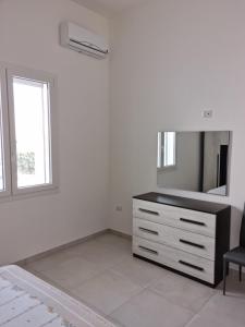een witte kamer met een dressoir en een spiegel bij VILLA BIANCA Porto Cesareo in Porto Cesareo