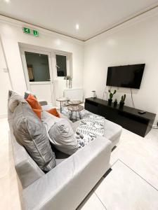 ロンドンにあるModern Double Room in Kensington Central Londonのリビングルーム(白いソファ、薄型テレビ付)