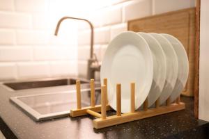 a stack of plates on a wooden stand on a kitchen counter at Stylish City Centre Studio - Grand Central House in Gibraltar