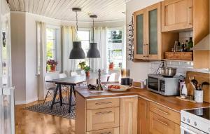 uma cozinha com armários de madeira e uma mesa em Beautiful Home In Gvle With Sauna em Gävle