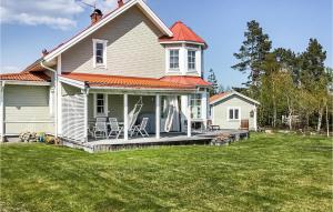 Una casa blanca con un porche con sillas. en Beautiful Home In Gvle With Sauna, en Gävle