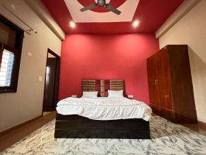 a bedroom with a red wall with a bed and a ceiling at OYO The Golf Star Near Pvr Ansal Plaza Greater Noida in Noida