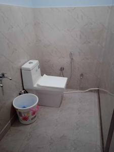 a bathroom with a toilet and a bucket at SPOT ON Black Bird in Meerut