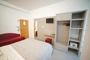 Habitación de hotel con cama y sofá rojo en Hotel Ricci, en Rímini