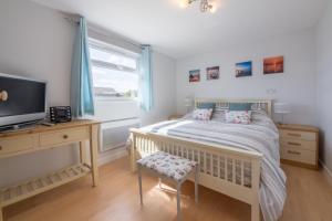 a bedroom with a bed and a tv and a window at Wyndham Beach House in Walcott