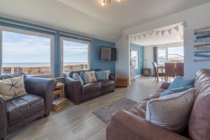 a living room with couches and a view of the ocean at Wyndham Beach House in Walcott