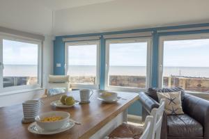 een eetkamer met een tafel en uitzicht op de oceaan bij Wyndham Beach House in Walcott