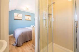 a bathroom with a shower and a bed in it at Wyndham Beach House in Walcott +25 photos