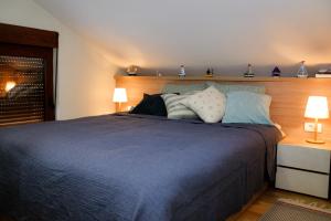 um quarto com uma cama com lençóis e almofadas azuis em Green Home - Lamela 1 Tivat em Tivat