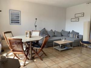 ein Wohnzimmer mit einem Tisch und einem Sofa in der Unterkunft small house 6p in bormes, quiet , hill-view in Bormes-les-Mimosas