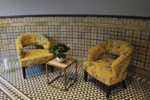 two yellow chairs and a table in a room at Stylish City Centre Studio - Grand Central House in Gibraltar