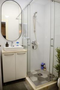 uma casa de banho com um chuveiro, um lavatório e um espelho. em Green Home - Lamela 1 Tivat em Tivat