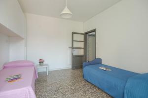a white room with a blue bed and a chair at Il Cerro - Sarnico in Sarnico