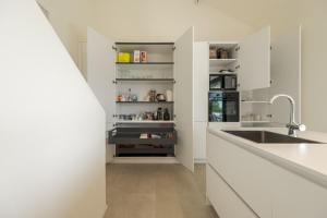 kuchnia z białymi szafkami i zlewem w obiekcie Villa Orizzonti w mieście Predore