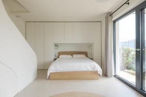 sypialnia z łóżkiem i dużym oknem w obiekcie Villa Orizzonti w mieście Predore