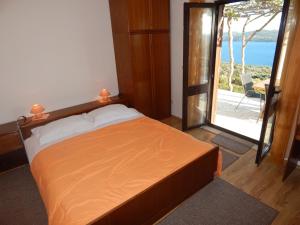 a bedroom with a bed with a view of the ocean at Apartments Drušković in Orasac