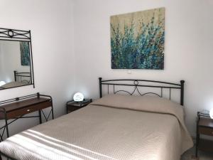 フィラにあるAratos Apartments - Kallisto 2bedroom Apartmentのベッドルーム1室(ベッド1台付)が備わります。壁には絵画が飾られています。