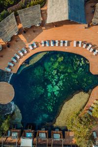 an overhead view of a pool with tables and chairs at Hotel Shibari - Restaurant & Cenote Club in Tulum