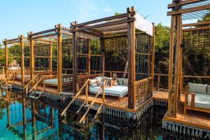 a pool house on the water with two people in it at Hotel Shibari - Restaurant & Cenote Club in Tulum