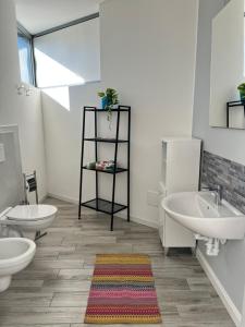 a bathroom with two sinks and two toilets at La camera del Testa Matta in Travedona