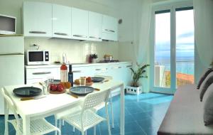 une cuisine avec une table et des chaises et une cuisine avec vue dans l'établissement Vista Mare & AC - Smeraldo Apartment, à Laigueglia