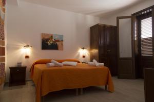 a bedroom with a bed with an orange blanket at B&B Piano di Sopra in San Vito lo Capo