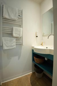 La salle de bains est pourvue d'un lavabo et d'un miroir. dans l'établissement Contact hôtel Les Ailes, à Challes-les-Eaux