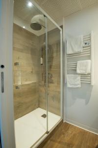 a shower with a glass door in a bathroom at Contact hôtel Les Ailes in Challes-les-Eaux
