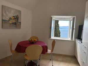 a dining room with a table and a window at Centrum Bol Apartment - One Minute from the Sea in Bol