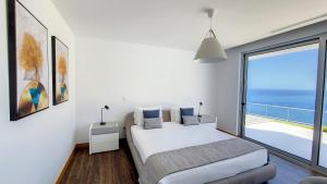 a bedroom with a bed and a view of the ocean at Villa Blue Horizon by LovelyStay in Tábua +38 photos