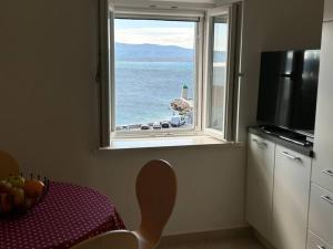 a kitchen with a view of the ocean from a window at Centrum Bol Apartment - One Minute from the Sea in Bol