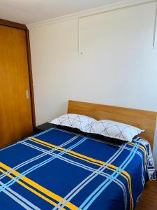 Bett mit blauer Bettdecke und 2 Kissen in der Unterkunft Bogotá Kings 401 in Bogotá