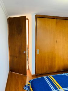 Zimmer mit einem Bett und einer Holztür in der Unterkunft Bogotá Kings 401 in Bogotá