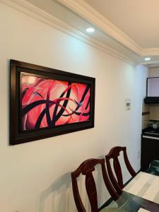 un cuadro colgado en una pared con dos sillas en Bogotá Kings 401, en Bogotá