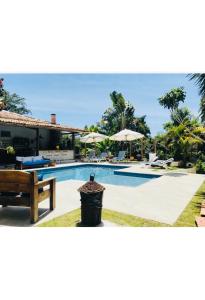 a swimming pool in front of a house at Pousada Pandoro in Trancoso