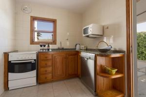 a kitchen with a white stove and a microwave at Villa Jaume in Pollença