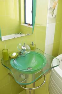 y baño con lavabo de cristal y espejo. en Spa Villa Crystal, en Hisarya