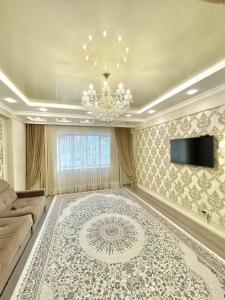 sala de estar con lámpara de araña y alfombra grande en Elite apartment in street Moskovskay 191, en Bishkek