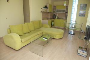 a living room with a yellow couch and a kitchen at Spa Villa Crystal in Hisarya