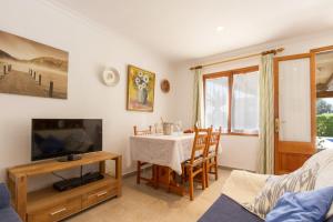 a living room with a table and a tv at Villa Jaume in Pollença